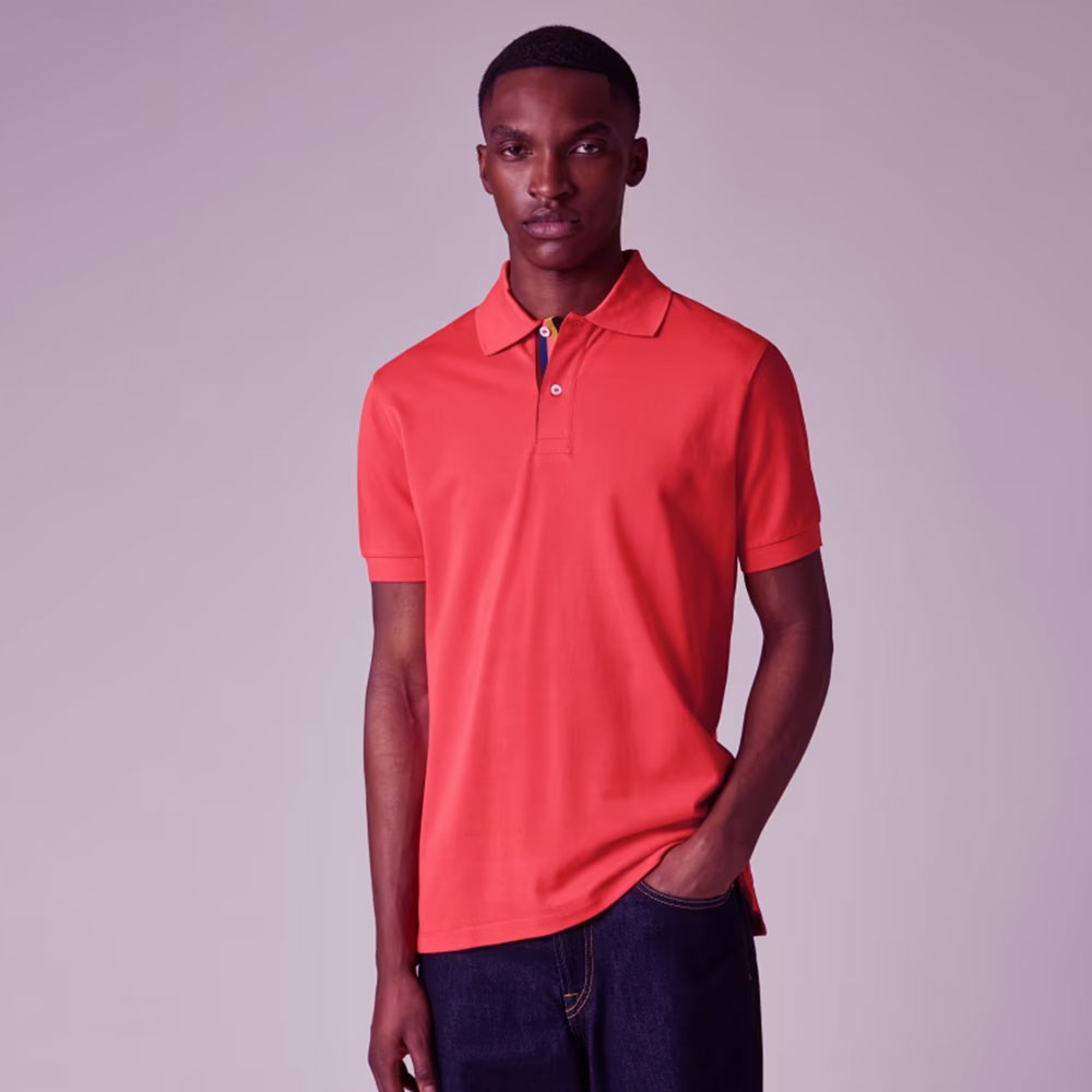 El polo Paul Smith Coral Pink 'Artist Stripe' Placket representa una visión moderna del clásico polo masculino.
