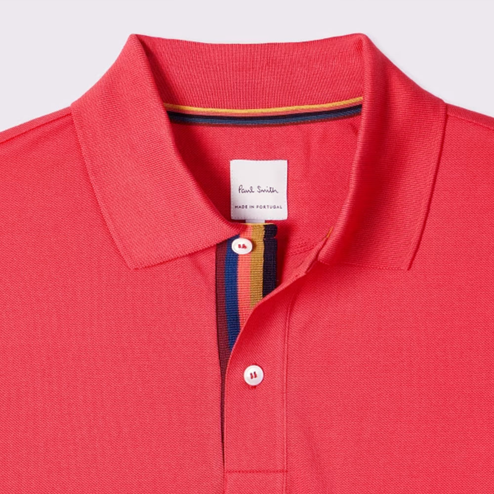 El polo Paul Smith Coral Pink 'Artist Stripe' Placket representa una visión moderna del clásico polo masculino.